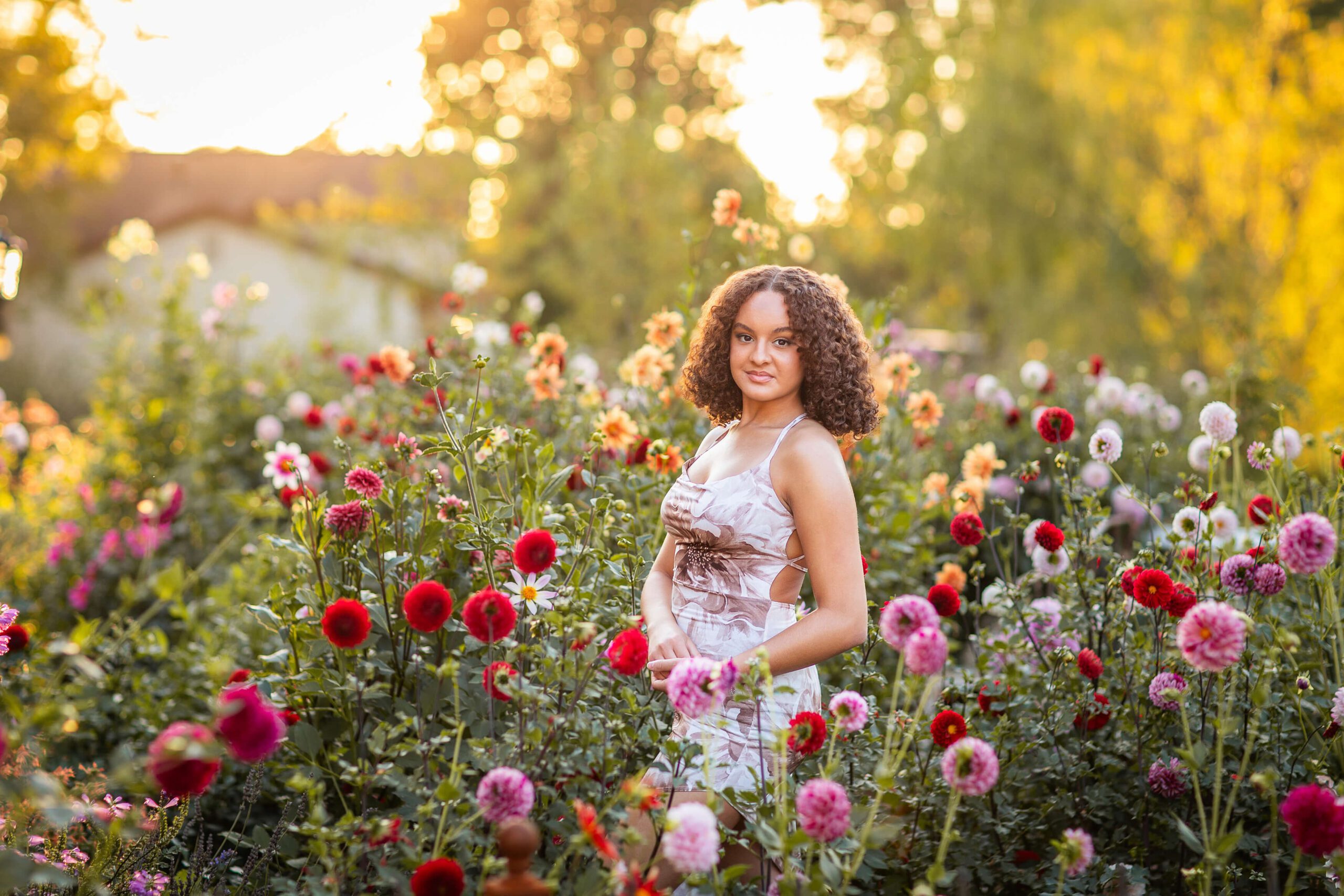A woman walks through a wildflower garden at sunset